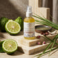 Bottle of repairing body oil with bergamot and leaves on a stone surface. Hello Wellness