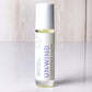 Hello Wellness Unwind aromatherapy essential oil roll-on in a clear glass bottle with a white cap, formulated for stress relief.