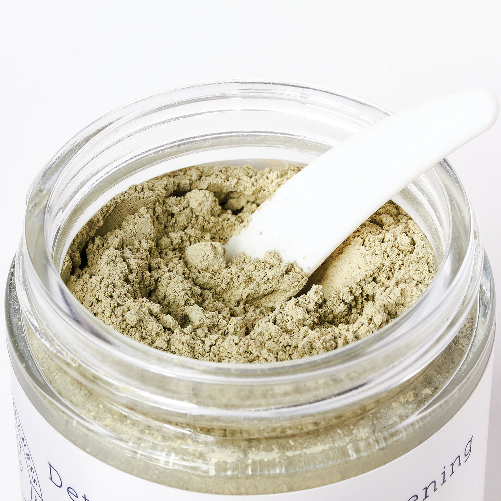 Open jar of green clay mask from Hello Wellness. Excellent for extracting excess sebum from oily skin & tightening.