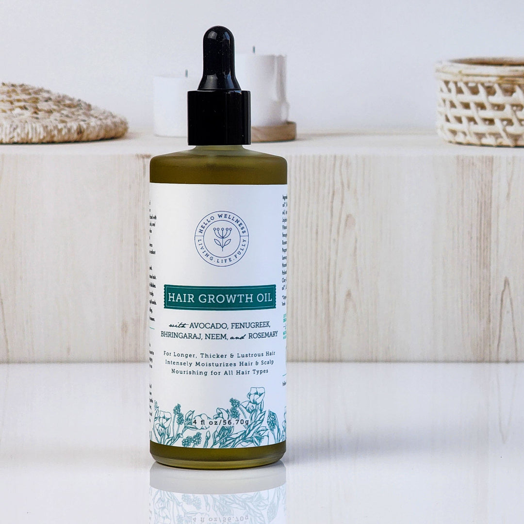 Bottle of hair growth oil with dropper on a wooden surface