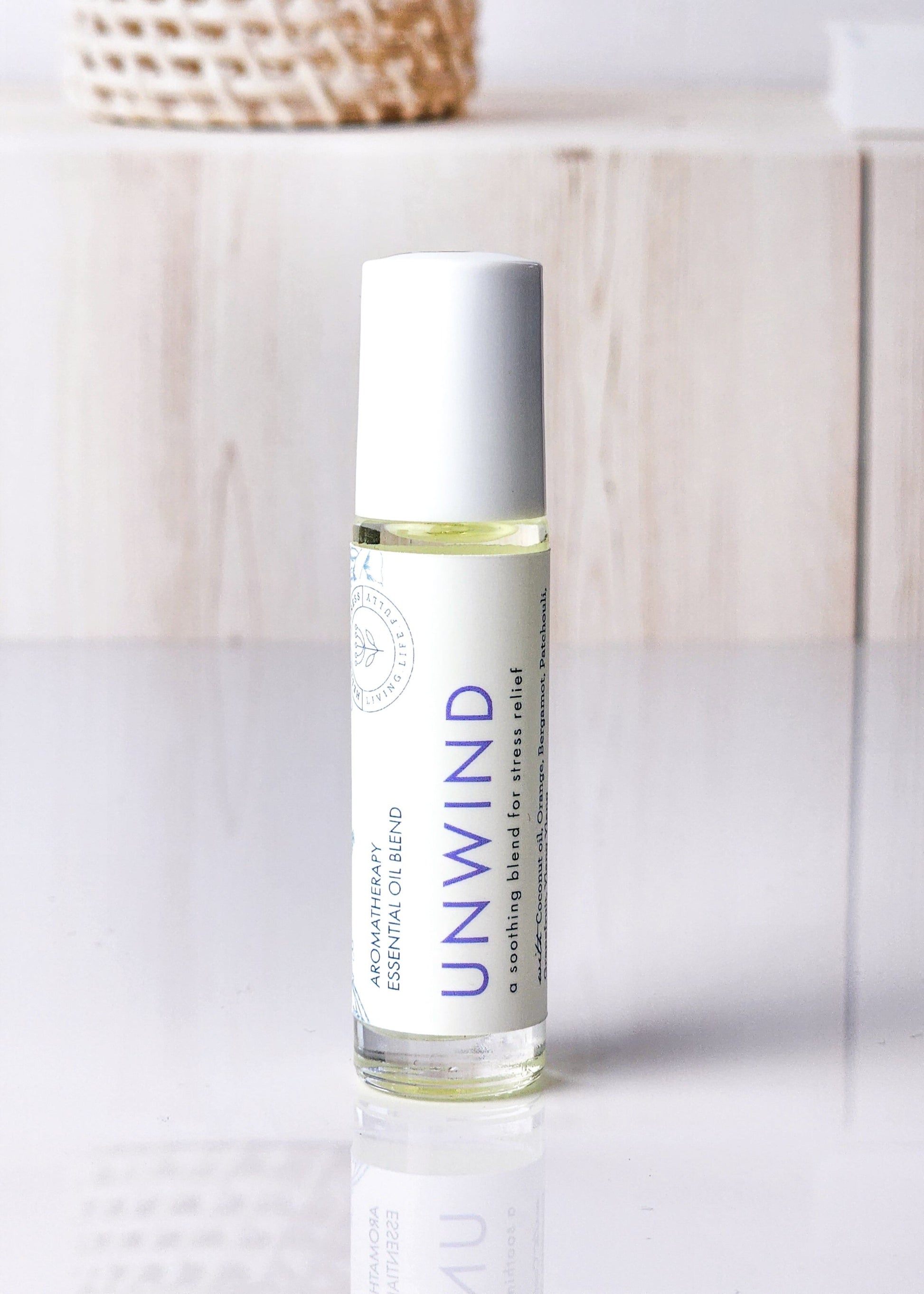 Roll-on bottle labeled 'Unwind' for stress relief