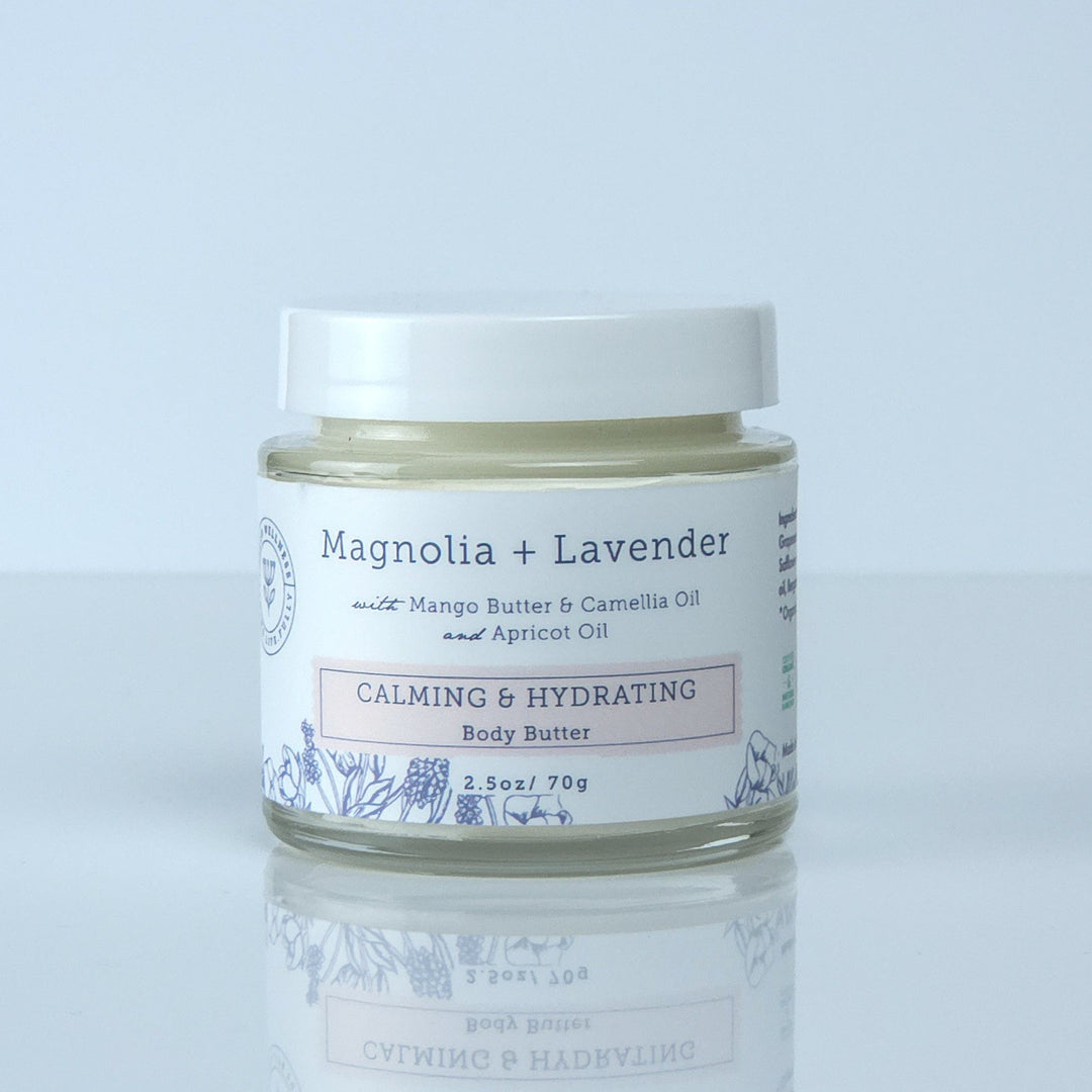 Jar of cream labeled 'Mentha + Lavender' on a light gray background