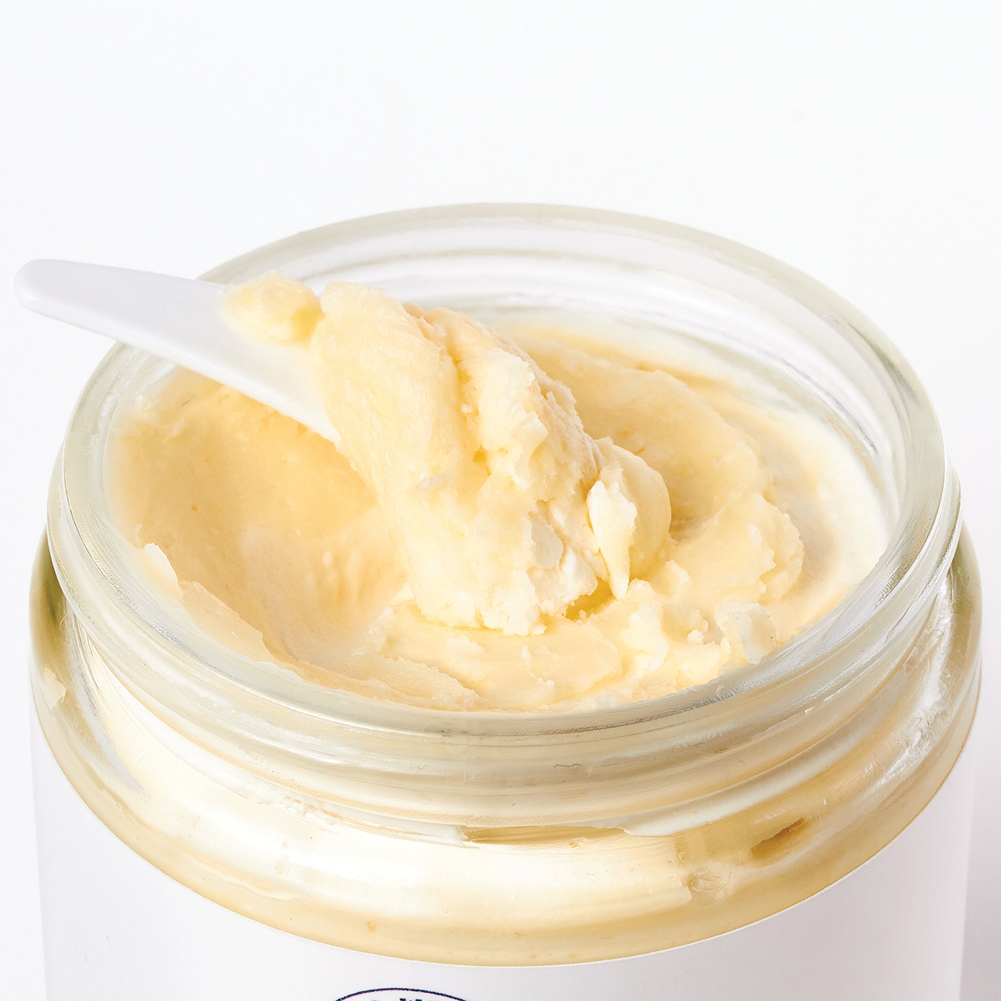 An open jar of body butter body cream that moisturizes dry skin & fades hyperpigmentation marks by Hello Wellness