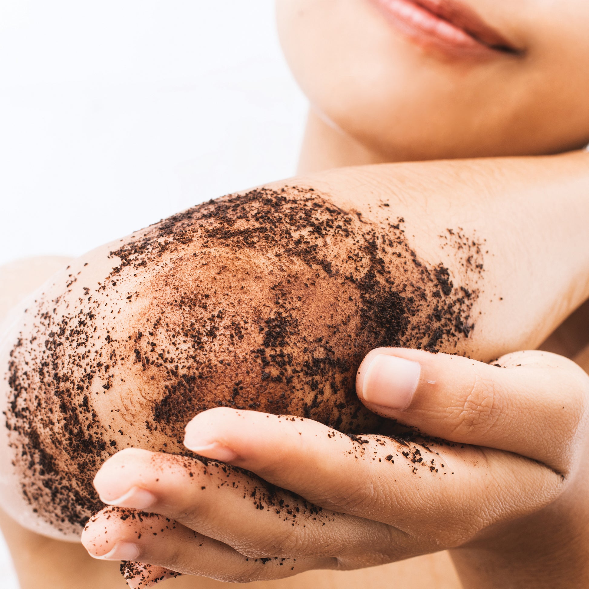 Woman scrubbing her elbow with Cocoa + Vanilla Coffee Body Polish by Hello Wellness. Scrub away dry, dead skin.
