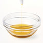 A bowl of hair oil by Hello Wellness Naturals. Made with natural ingredients to nourish and protect the hair & scalp.