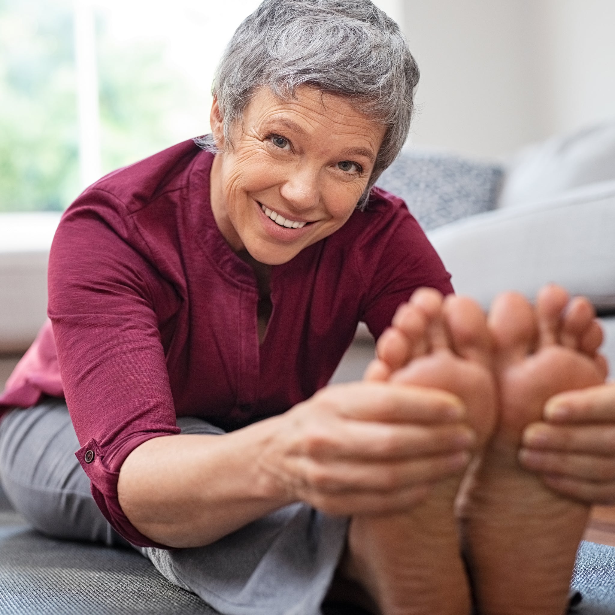 Senior woman stretching on a yoga mat