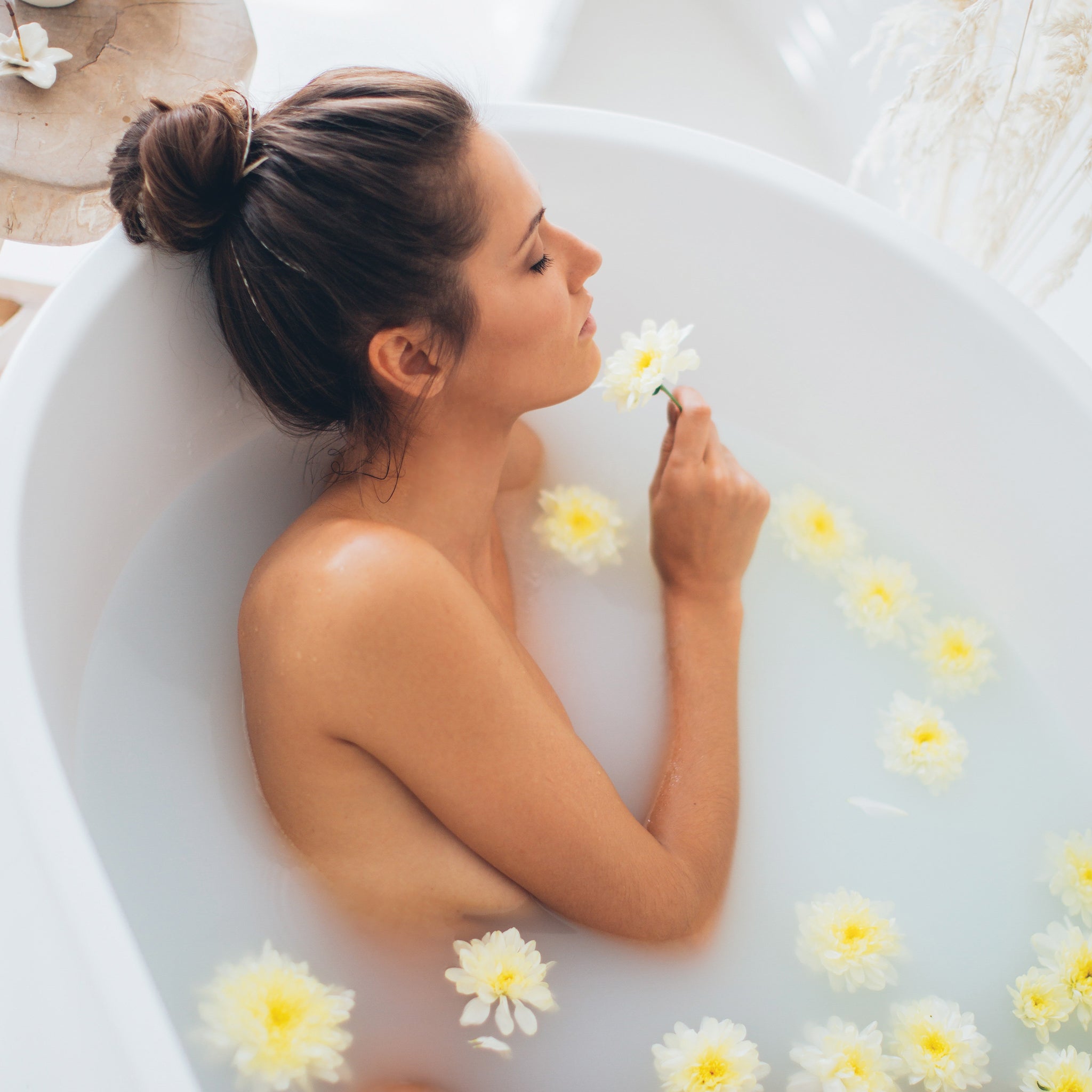 Woman soaking in a tub of coconut & honey bath milk that hydrates & moisturizes dry. Perfect for sensitive skin.